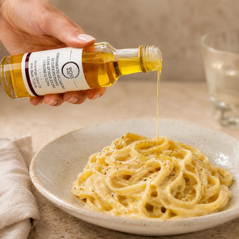Huile d’Olive à la Truffe Noire étant versé en filet sur chaud crémeux tagliatelle