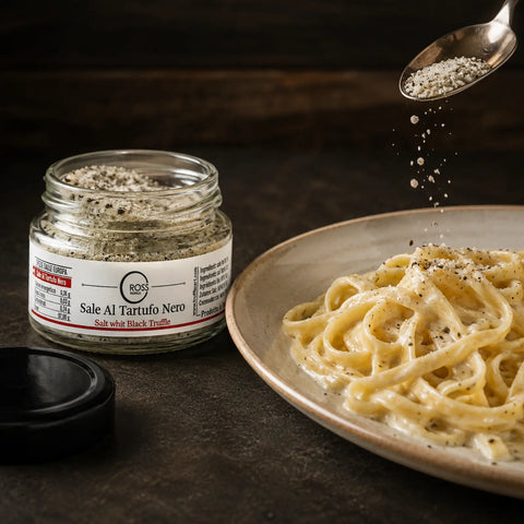 Black truffle salt being sprinkled over warm creamy tagliatelle before serving