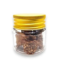 Brown dried spring truffle Tuber Borchii in glass jar with gold lid for gourmet cooking