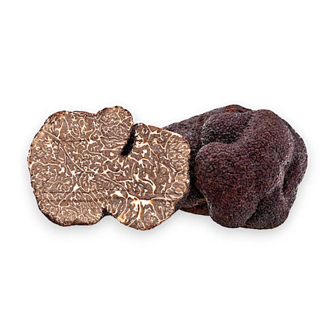 Truffes noires entières et coupées de Tuber melanosporum révélant leur intérieur sombre et marbré